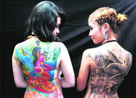 BACK BEAUTY: Thai models show off their tattooed backs during the annual tattoo festival in Bangkok on Monday.