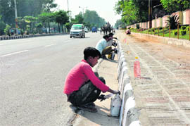 Workers busy painting footpaths in Jammu.