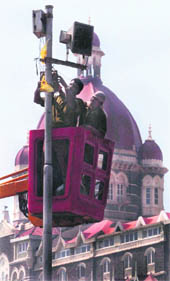 Workers adjust lamps on an electric post as beautification work is in full swing outside the Taj Mahal hotel near the Gateway of India, ahead of the visit of US President Barack Obama, in Mumbai on Tuesday. 
