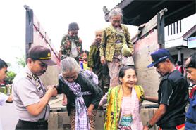 A police officer helps a villager step down from a truck after she was evacuated from her village near the ancient city of Yogyakarta, on Tuesday.