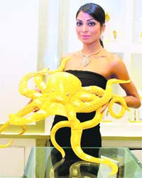 A model displays a 4 kg gold replica of Paul the octopus, which shot into fame for its predictions on soccer World Cup 2010 matches, at the opening of a jewellery showroom in Gurgaon