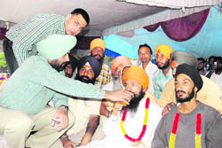 Patiala Deputy Commissioner Dipinder Singh offers juice to the Punjab unit president of the Unemployed Linemen Union, Piramal Singh, who was observing a fast unto death, in Patiala on Wednesday