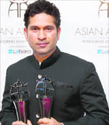 Sachin Tendulkar poses for photographs after winning the Outstanding Achievement in Sport and People's Choice Awards at the The Asian Awards in London on Wednesday.