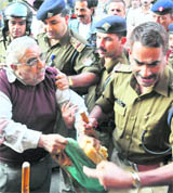 A shopkeeper jostles with policemen while protesting 