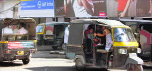 Autorickshaws ply on a Gurgaon road.