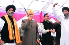 Chief Minister Prem Kumar Dhumal carries a sword at a function held in Nalagarh