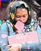 A woman hugs a grave marker during a mass burial for victims of the Mount Merapi eruption