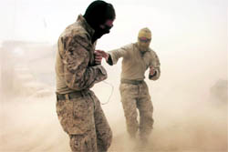 Benjamin Brickman (right) from the 1st Battalion 8th Marines Alpha Company reaches out to his comrade Brandon Voris as they struggle through heavy winds during a sandstorm at their remote outpost near Kunjak in southern Afghanistan's Helmand province on Thursday