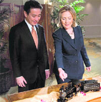 US Secretary of State Hillary Rodham Clinton gifts Japanese Foreign Minister Seiji Maehara a train set in Honolulu, Hawaii, on Wednesday