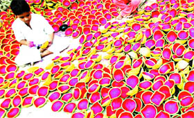 A child colours earthen lamps for Diwali in Amritsar.