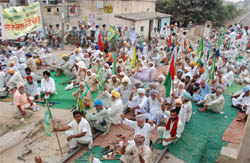 Members of various farmer organisations blocking the Bathinda-Ambala railway track in protest against non-procurement of paddy, at Rampura