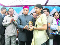 Chief Minister PK Dhumal gives away prize to a student in annual prize distribution function at a school at Lamblu, Hamirpur, on Friday.