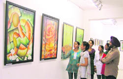 Viewers take a look at paintings displayed at the ongoing exhibition at Gallery Artmosphere in Ludhiana.