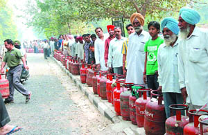 LPG consumers wait for their turn outside a godown of a gas agency in Bathinda on Saturday.