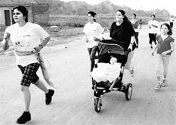 A mother runs with her baby in a pram during a marathon organised by the Running and Living Infotainment in Panchkula on Saturday