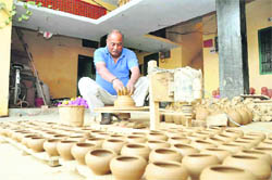 A potter makes earthen pots for Diwali in Dehradun on Friday.