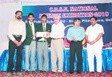 Union Human Resource Development Minister Kapil Sibal presents an award to students of Kasiga School in New Delhi.