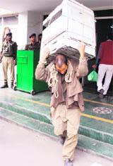 A porter carries official files from the Civil Secretariat during the Durbar Move in Srinagar