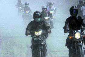 Motorists ride on an ash-covered street during an ash fall from the eruption of Mount Merapi in Pakem on Saturday.