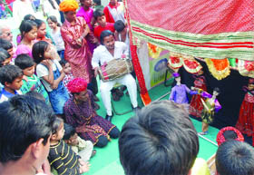 Children gather to see the puppet show during a health mela at Laxmi Bai Nagar in New Delhi on Sunday. 