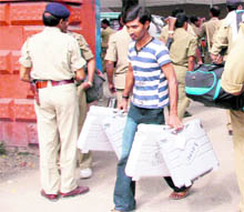 An official carries voting material to a polling booth ahead of the fourth phase of polling for the Assembly elections in Patna, Bihar, on Sunday
