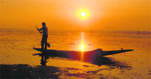  A Kashmiri boatman at sunset on the Dal Lake in Srinagar on Monday.