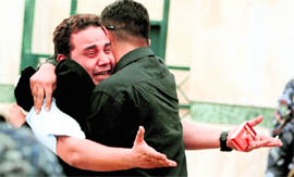 An Iraqi man mourns the death of his wife in Baghdad on Monday.