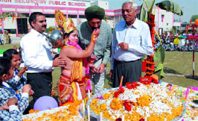 A student dressed as Lord Hanuman offering a sweet to Deputy Commissioner Gurkirat Kirpal Singh during the Mahavir Jayanti celebrations at the MSD Public School in Bathinda on Tuesday. Chairman of the school Chiranji Lal Garg looks on.