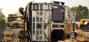 A loaded truck turns on its side on the highway near Badkhal Mod petrol station in Faridabad.