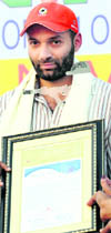 Commonwealth Games gold medallist in shooting Harpreet Singh poses for photographers after receiving the Karnal Ratna Award in Karnal on Tuesday.
