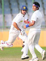 Bengals Ashok Dinda (R) watches as Virat Kohli takes a run in New Delhi on Tuesday