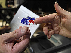 A volunteer gives a sticker to a voter at a polling place in Washington on Tuesday.
