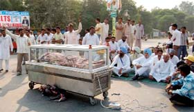 The kin of Gautam Tanwar and other Congress workers stage protest on the Malout-Bathinda road at Husnar chowk in Gidderbaha on Wednesday
