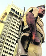 A cop stands guard near Taj hotel in Mumbai.