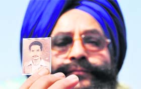 Surinder Singh shows a photograph of when he had felt compelled to cut his hair