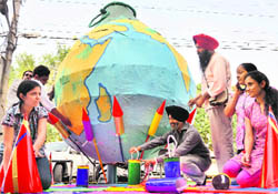 Artists make a globe in the shape of a grenade to send out a message for a green Diwali in Ludhiana on Thursday.