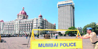 A cop pushes a barricade in front of the Taj Hotel as part of security measures ahead of US Presidents visit.
