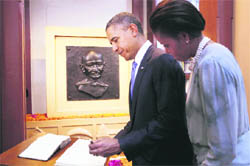 US President Barack Obama and First Lady Michelle Obama sign the guest book as they tour the Mani Bhavan Gandhi Museum in Mumbai on Saturday.
