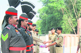 A BSF officer gives a box of sweets to an officer of Pakistan Rangers at Hussainiwala JCP on Friday. 