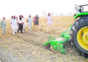 Jaideep Singh shows his technique of decomposing paddy straw in the fields to agro-scientists and villagers in Moga. 