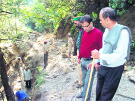 Mussoorie Palika President OP Uniyal inspects the work on the road at the Jharipani Falls in Mussoorie.