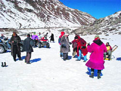 Tourists enjoy at a snow point on the way to 13,050-foot-high Rohtang Pass.