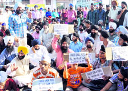Members of the Sikh community raise slogans while blocking the National Highway in protest against the harassment of some Sikh families in the Valley on Sunday