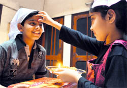 A girl applies tilak on the forehead of her brother on the occasion of Bhai Dooj in Ludhiana on Sunday