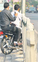 Motorcyclist crosses the broken fencing on the road divider near Pakhowal Road in Ludhiana