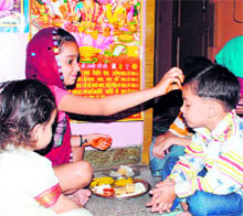 A girl applies tilak to her brother on the occasion of Bhai Duj, 