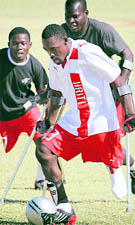 Haitian national amputee soccer team player Josue Cajuste, front, moves the ball upfield during a match on Saturday