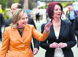 Power women: US Secretary of State Hillary Clinton waves to onlookers while walking to lunch with Australian Prime Minister Julia Gillard in Melbourne on Sunday.