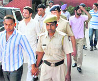 Policemen take the 13 students, arrested for rioting and assault on Monday, from the Sector 11 police station to the district courts in Chandigarh on Tuesday