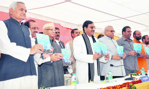 Chief Minister Ramesh Pokhriyal Nishank, along with former Chief Minister ND Tiwari, releases a souvenir at a state function in Dehradun on Tuesday.